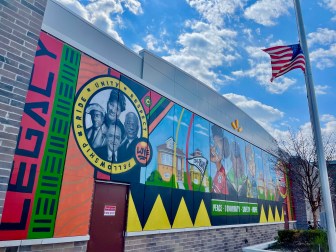A colorful mural with faces of Black Americans and words including 
